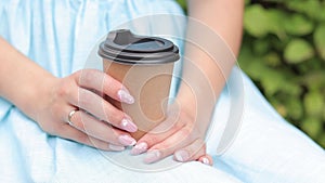 Craft cup with coffee in the hands of a woman close-up