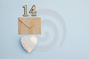 Craft envelope with number 14 over it and white heart on the blue background. Romantic love letter for the Valentine`s day concep