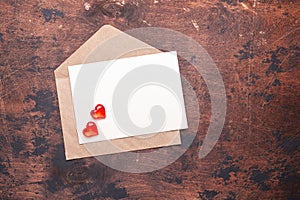 Craft envelope with red hearts on a vintage wooden background Piece of paper Valentine day concept Flat lay