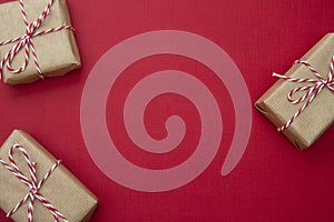 Craft gift boxes over red background. Christmas mockup with copy space. winter holidays with presents, top view, flat lay