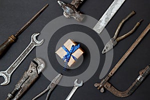 Craft gift with vintage old tools on black paper background. Fathers day concept. Flat lay