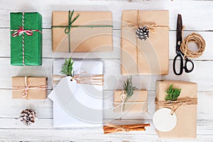 Craft and handmade Christmas present gift boxes and rustic decoration on white wooden board.