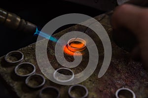 Craft jewelery making with professional tools. Macro shot. A handmade jeweler process, manufacture of jewellery. Melting metal