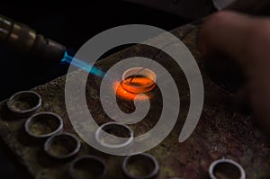 Craft jewelery making with professional tools. Macro shot. A handmade jeweler process, manufacture of jewellery. Melting metal