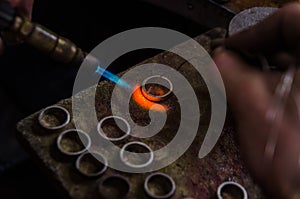 Craft jewelery making with professional tools. Macro shot. A handmade jeweler process, manufacture of jewellery. Melting metal