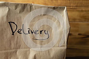Craft package with food delivery on dark wooden background