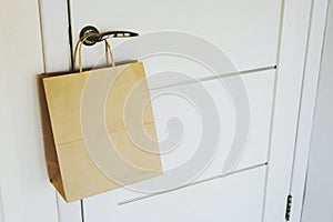 The craft package hangs on the handle from the front door.