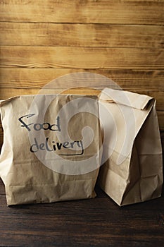 Craft packages with food delivery on dark wooden background