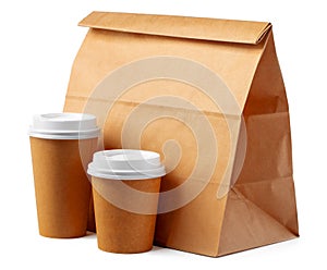 Craft paper bag and coffee to go cups on white background