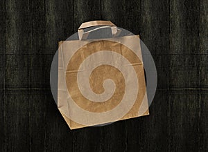 Craft paper bag isolated on dark wooden background