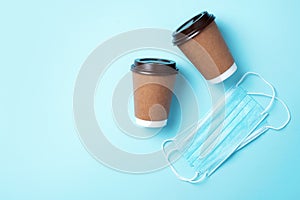 Craft paper cups with coffee to go and food box, lunch on blue background. Top view. Banner, copy space. Safe delivery, take away