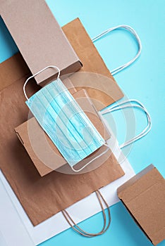 Craft paper cups, food box, gloves, bags, mask on blue background. Top view. Banner, copy space. Safe delivery, take away only