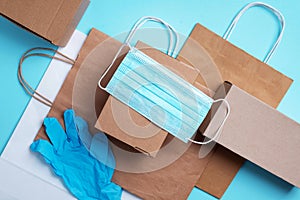 Craft paper cups, food box, gloves, bags, mask on blue background. Top view. Banner, copy space. Safe delivery, take away only