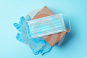 Craft paper cups, food box, gloves, bags, mask on blue background. Top view. Banner, copy space. Safe delivery, take away only