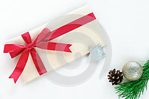 A craft paper envelope tied with a red festive ribbon is intended for a Christmas present.