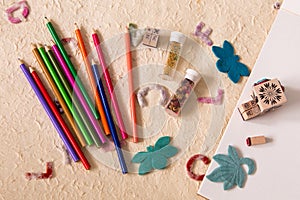 Craft station with colour pencils, bottles of beads, felt butterflies and leaf, drawing pad and wooden stamps with different motif