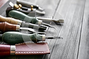 Craft tools for work with leather on wooden table