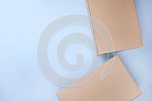 Craft unlabeled cardboard package box presented on stressed brushed on a blue background. The concept of delivery, mail