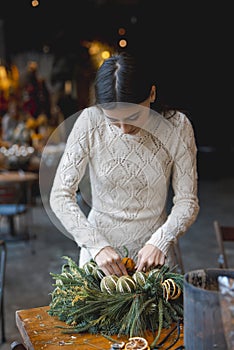 In a crafting masterclass, a young lady learns to make Christmas decorations.