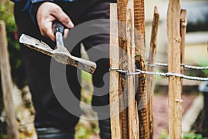 Craftman with a hammer, paling fence or picket fence photo