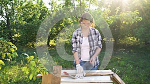 Crafts woman puts on protective glasses and gloves before processing wood plank