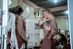 craftsman in apron happy when making phone calls