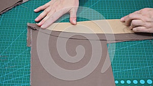 Craftsman attaches the paper pattern to the fabric by pins