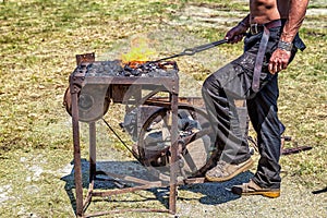 Craftsman at blacksmith forge.