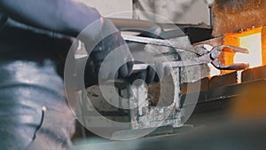 Craftsman blacksmith working with steel in forge