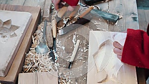 A craftsman carved a baking dish gingerbread and cookies out of wood with a knife. Art wood carver makes wood carvings