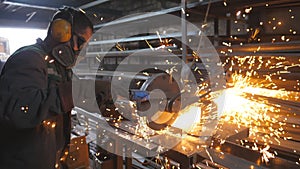 Craftsman with circular saw sawing steel in workshop. Man use saw cutting machine to cut metal. Industrial professional