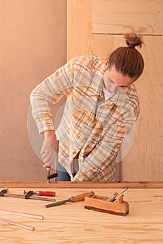 Craftsman with clamps working with wood. Male carpenter installing clamps and vices for gluing wooden details on
