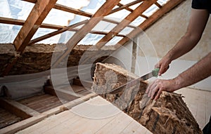 Craftsman cutting insulation material to insulate the attic photo