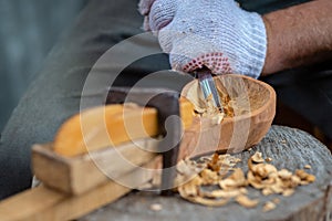 Craftsman demonstrates the process of making wooden spoons handmade using tools. National crafts concept.