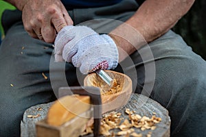 Craftsman demonstrates the process of making wooden spoons handmade using tools. National crafts concept.