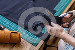 Craftsman drawing scheme lining for bag on tissue creating leatherwork at studio leather workshop photo