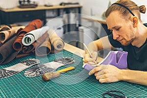 Craftsman drawing shoe last pattern creating leatherwork at studio leather workshop