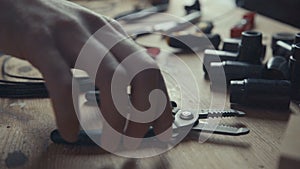 Craftsman electrician working on wiring using pair of pliers to strip