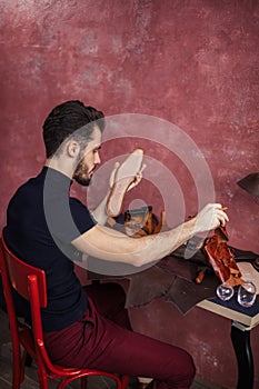 Craftsman holding an insole and leather at workplace