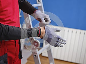 Craftsman holding a saw ready to perform home renovation. Worker in work clothes on a construction site on an aluminum folding