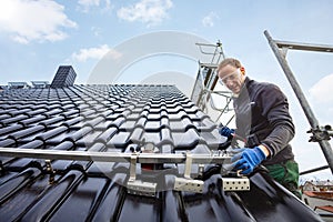 Craftsman installing the solar panel mounting system on a roof