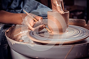 Craftsman master sculptor works with clay on a Potter's wheel and at the table with the tools. Inspiration and