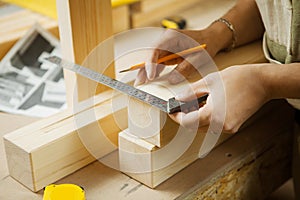 Craftsman measure wooden planks with help of ruler. Woodworker workshop