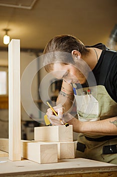Craftsman measure wooden planks with ruler. Woodworker at workshop