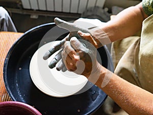 Craftsman is molding the clay into the desired shape on potter& x27;s wheel. Made ceramic products. Selective focus.