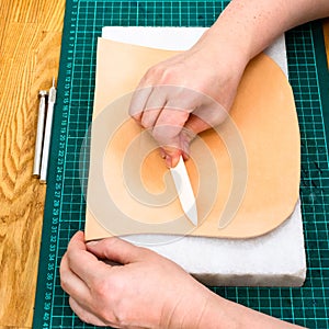 Craftsman polishes leather using flat burnisher