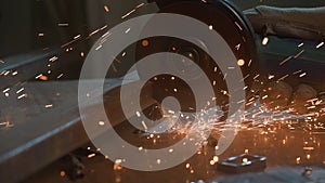 Craftsman in protective gloves working with grinder at industrial plant, man grinding iron detail, sparks flying around