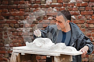 Craftsman restorer working with gypsum model