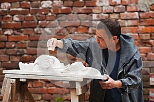 Craftsman restorer working with gypsum model