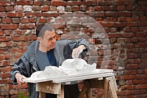 Craftsman restorer working with gypsum model